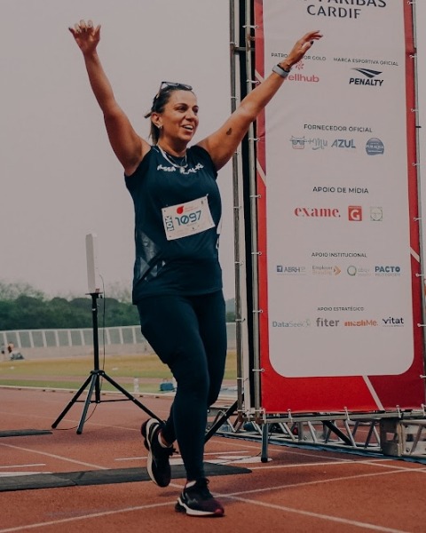 Atleta celebrando ao cruzar a linha de chegada no Corporate Games